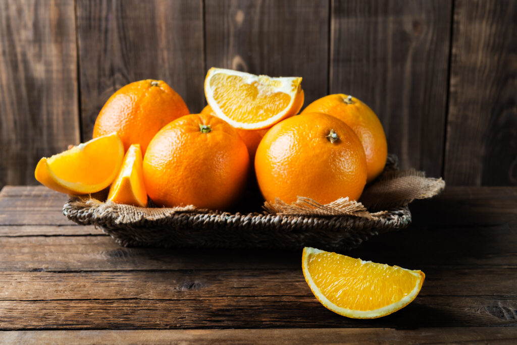 Fresh ripe oranges on dark wooden background